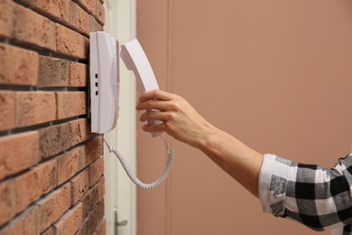 Man answering intercom call at home, closeup