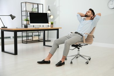 Young businessman relaxing in office chair at workplace