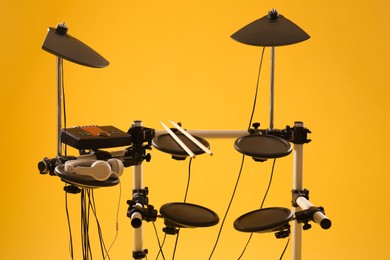 Modern electronic drum kit on yellow background. Musical instrument