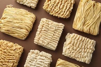 Photo of Flat lay composition with different quick cooking noodles on color background