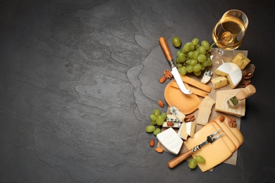 Flat lay composition with different sorts of cheese and knives on black table. Space for text