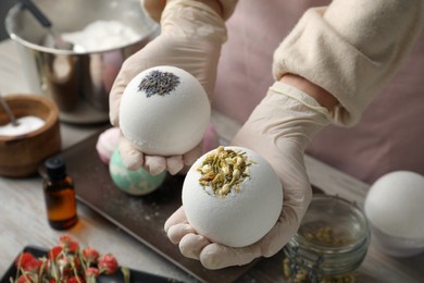 Woman in gloves with self made bath bombs at table, closeup