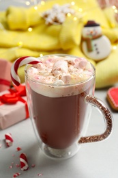 Photo of Composition with delicious marshmallow drink, festive items and yellow sweater on light table