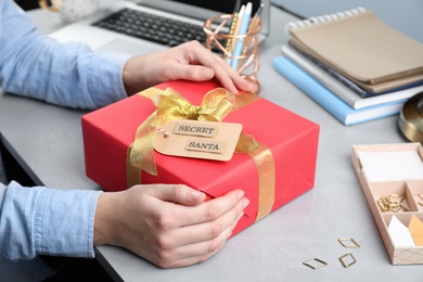 Man with present from secret Santa at workplace, closeup