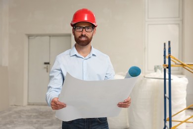 Professional engineer in hard hat with draft indoors