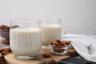 Photo of Glasses of delicious date smoothie and nuts on wooden board. Space for text