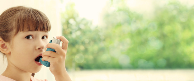 Image of Little girl using asthma inhaler on blurred background, space for text. Banner design
