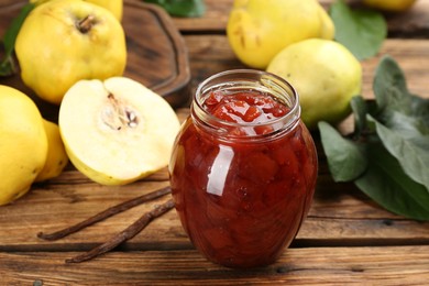 Photo of Delicious quince jam and fruits with vanilla on wooden table, closeup
