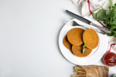 Delicious fried breaded cutlets served on white table, flat lay. Space for text