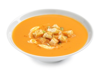 Tasty creamy pumpkin soup with croutons and seeds in bowl on white background