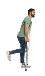 Young man with axillary crutches on white background