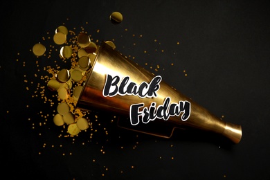 Phrase Black Friday, horn and confetti on dark background, flat lay