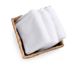 Soft folded terry towels in wicker basket isolated on white, top view
