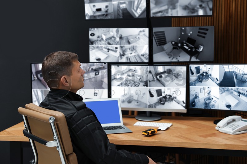 Photo of Security guard monitoring modern CCTV cameras indoors