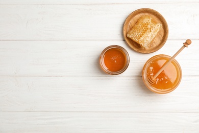 Flat lay composition with fresh honey on wooden background