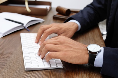 Male lawyer working with computer at table, closeup