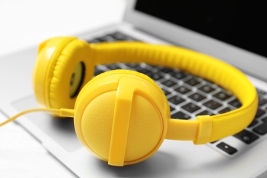 Stylish headphones on laptop, closeup. Modern technology