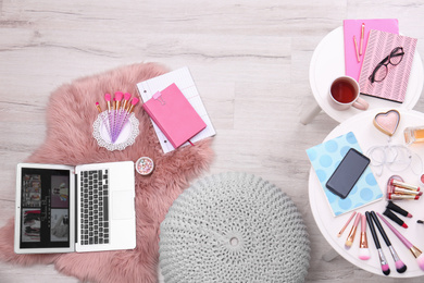 Photo of Top view of fashion blogger's workplace with laptop and cosmetics