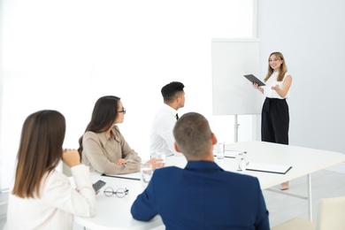 Female business coach talking to audience in office