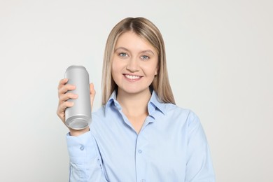 Photo of Beautiful happy woman holding beverage can on light background