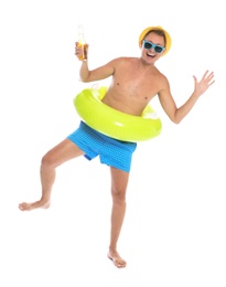 Shirtless man with inflatable ring and bottle of drink having fun on white background