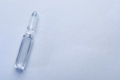 Pharmaceutical ampoule with medication on white background, top view. Space for text