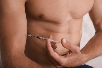 Athletic man injecting himself, closeup view. Doping concept