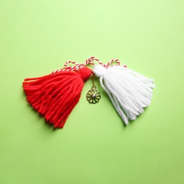 Traditional martisor on green background, top view. Beginning of spring celebration