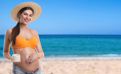 Young pregnant woman with sun protection cream on beach. Space for text