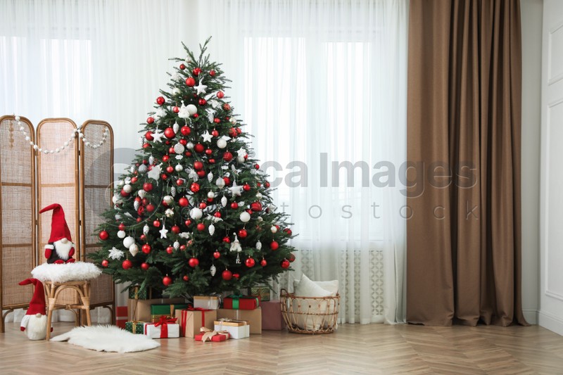 Cozy room interior with Christmas tree, gifts and beautiful festive decor, space for text