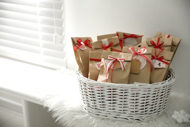 Set of gifts in basket and Christmas decor on window sill indoors. Advent calendar