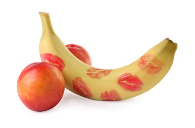 Banana with red lipstick marks and nectarines symbolizing male genitals on white background. Potency concept