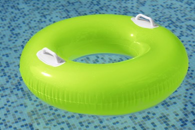 Light green inflatable ring floating in swimming pool