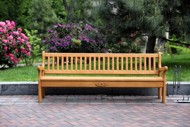 Comfortable wooden bench in beautiful garden. Place for rest