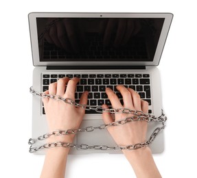 Woman with chained hands typing on laptop against white background, top view. Internet addiction
