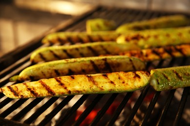 Cooking delicious fresh zucchini on grilling grate in oven, closeup