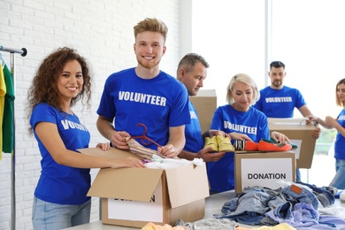 Team of volunteers collecting donations in boxes indoors