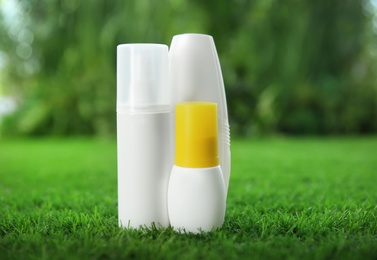 Photo of Many different insect repellents on green grass