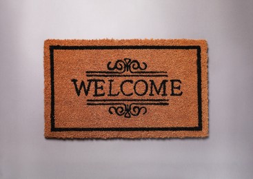 Photo of Doormat with word Welcome on grey background, top view