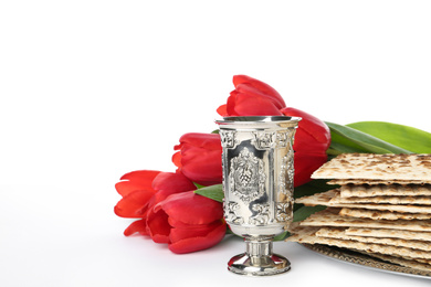 Passover matzos, silver goblet and flowers on white background. Pesach celebration