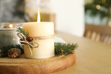Burning scented conifer candles and Christmas decor on wooden table, closeup. Space for text