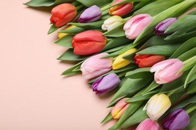 Photo of Beautiful colorful tulips on pale pink background. Space for text