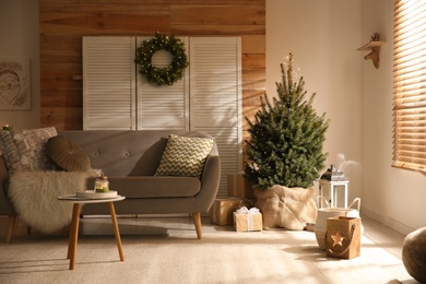 Spacious room interior with small Christmas tree and wreath