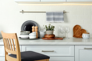 Set of clean tableware on white countertop in kitchen