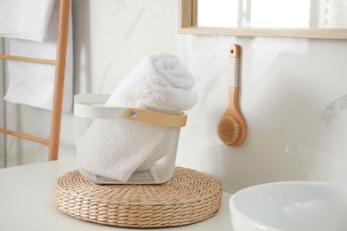 Basket with clean towel in modern bathroom interior