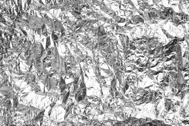Crumpled silver foil as background, closeup view
