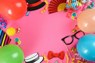 Frame of colorful serpentine streamers and other party accessories on pink background, flat lay. Space for text