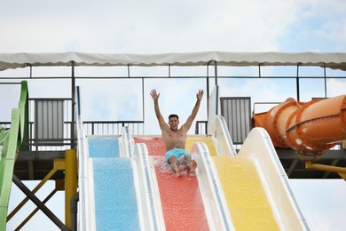 Photo of Handsome man on slide in water park