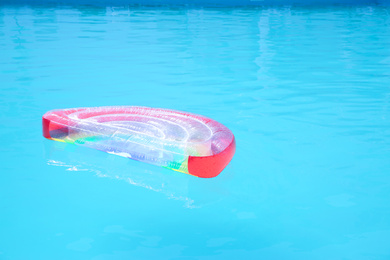 Inflatable mattress in swimming pool on sunny day