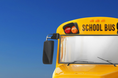 Yellow school bus on blue background, closeup. Transport for students